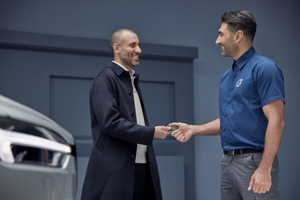 Car salesman shaking hand with buyer